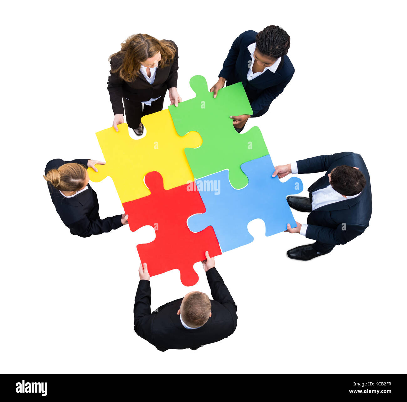Elevato angolo di visione di un businessman risolvendo puzzle su sfondo bianco Foto Stock