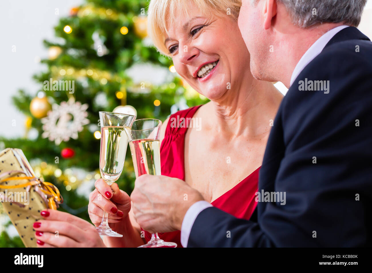 Coppia senior per celebrare il Natale con champagne Foto Stock