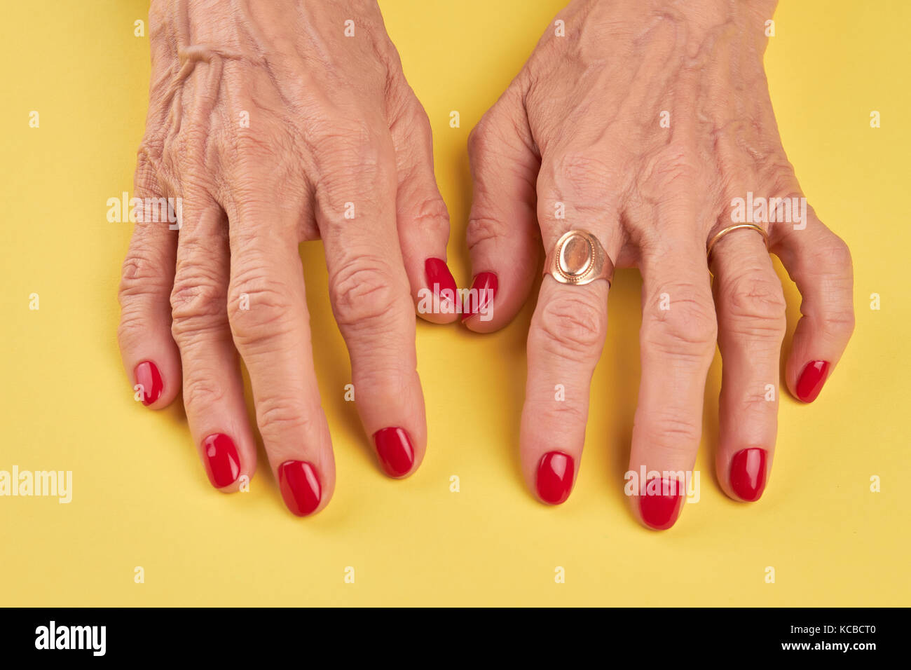Donna anziana mani con manicure rosso. Foto Stock