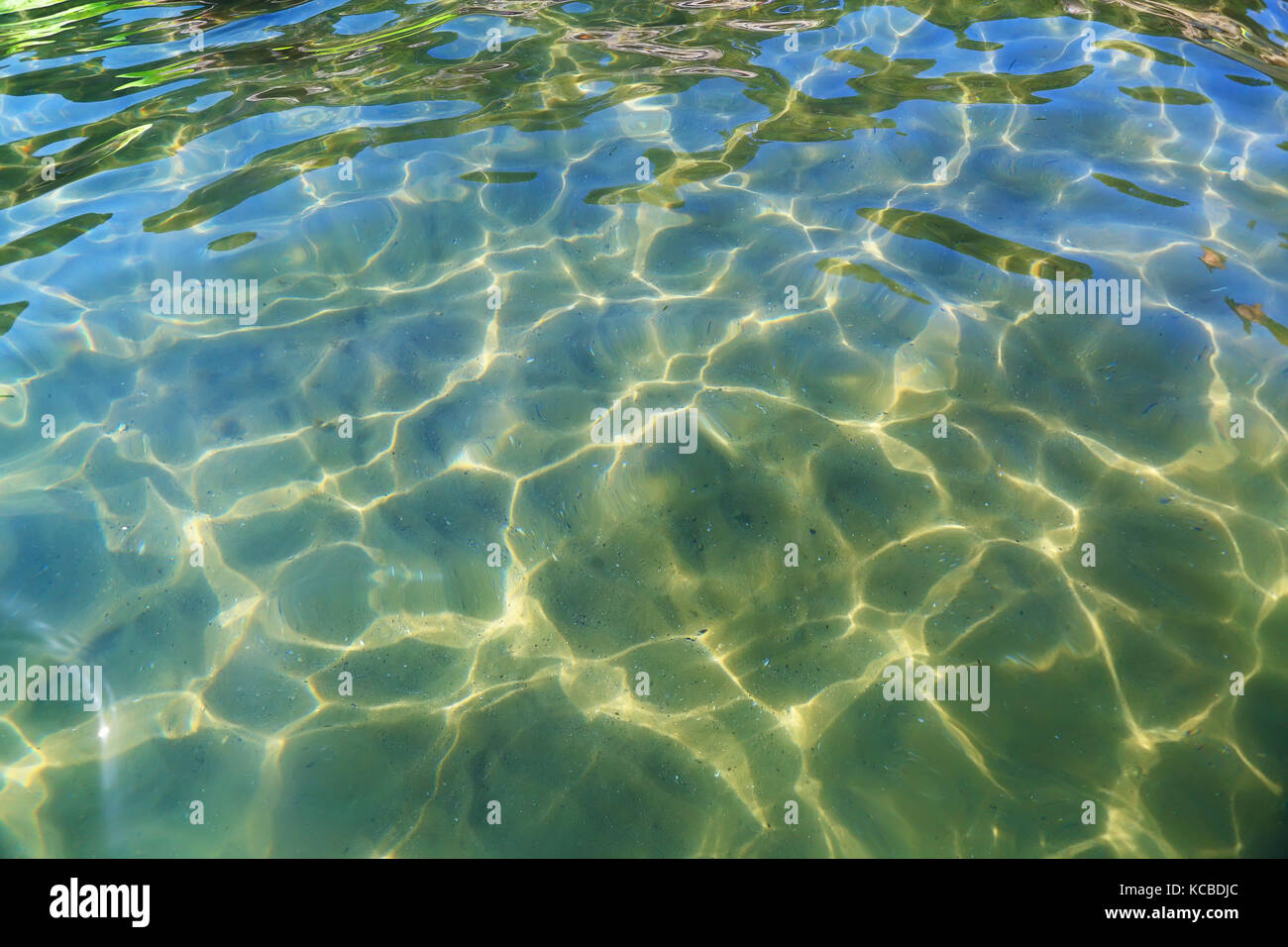 Acqua di mare sullo sfondo. L'acqua di mare con modelli di sole da sopra. acque trasparenti del mar mediterraneo in costa dorada resort. Foto Stock