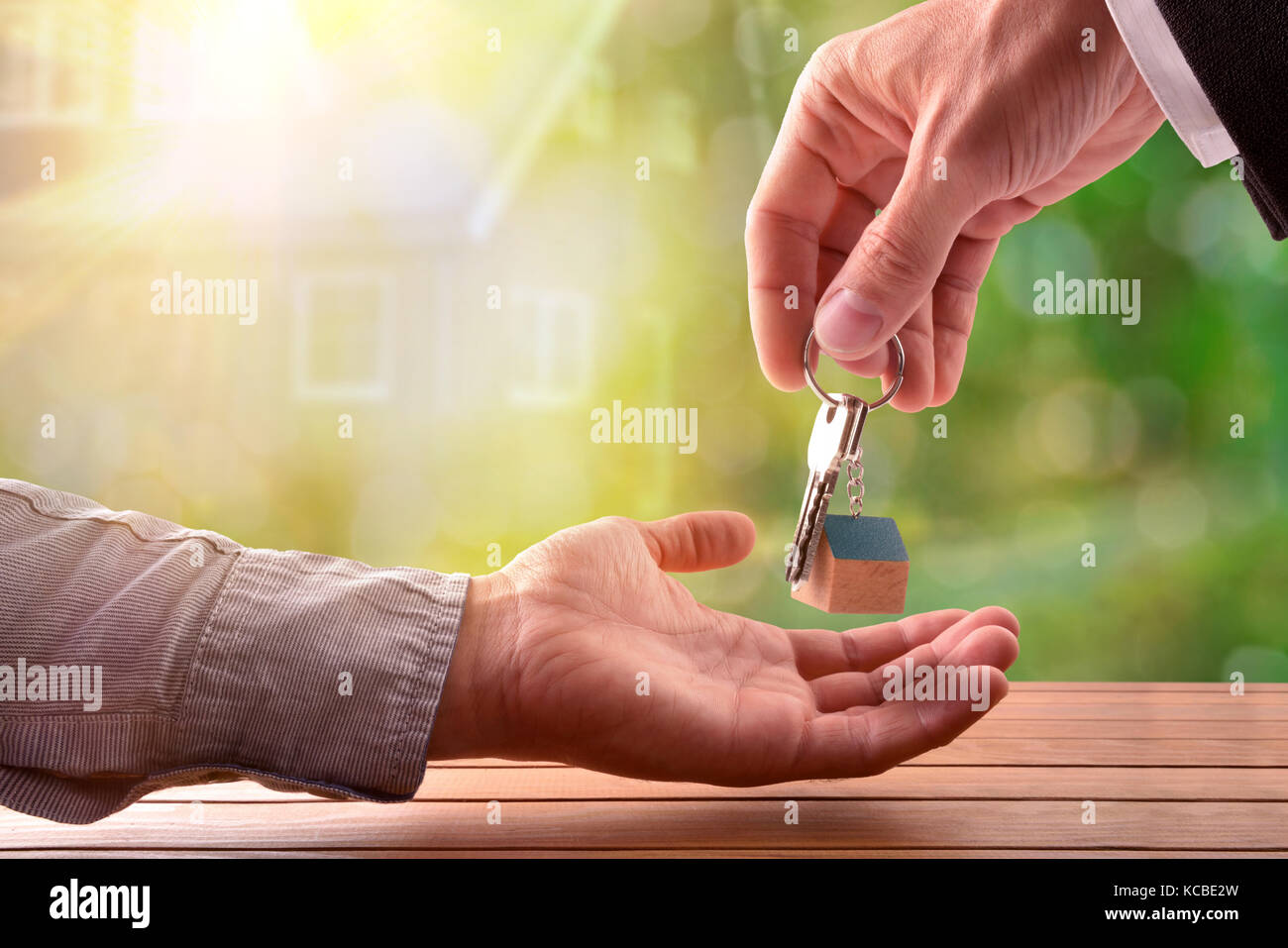 Agente di dare le chiavi per il compratore di una casa con casa su sfondo natura Foto Stock