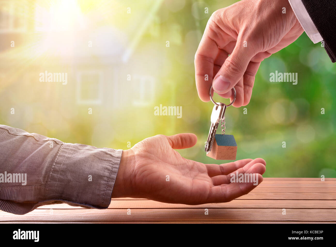 Agente di dare le chiavi per il compratore di una casa con casa su sfondo natura Foto Stock