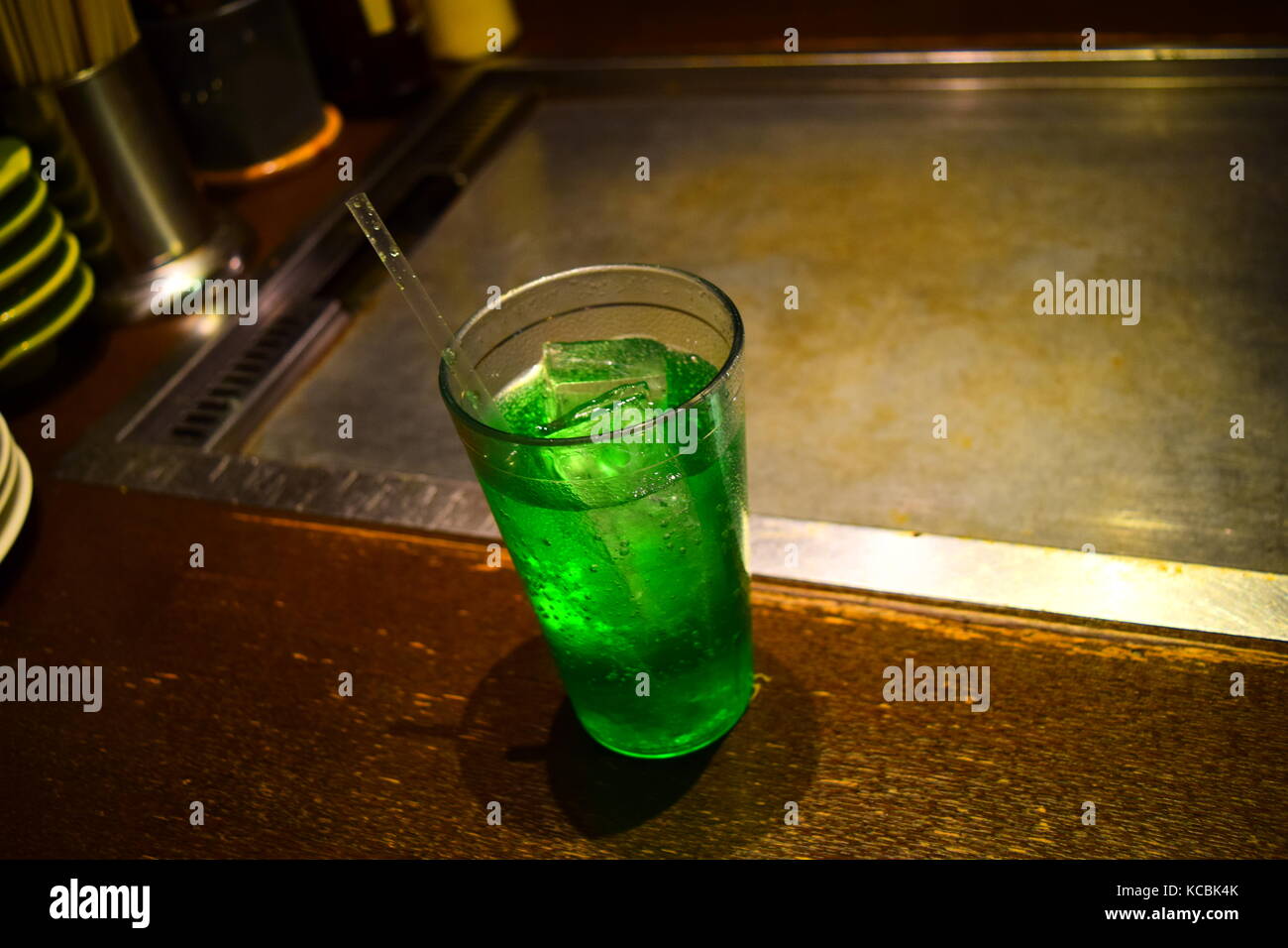 Un bicchiere di verde soda con una cannuccia e cubetti di ghiaccio è servita in un ristorante giapponese Foto Stock