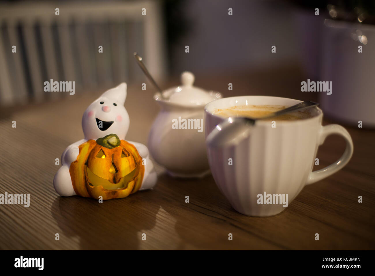 Ghost tenendo la zucca sul tavolo di legno alla notte di Halloween Foto Stock