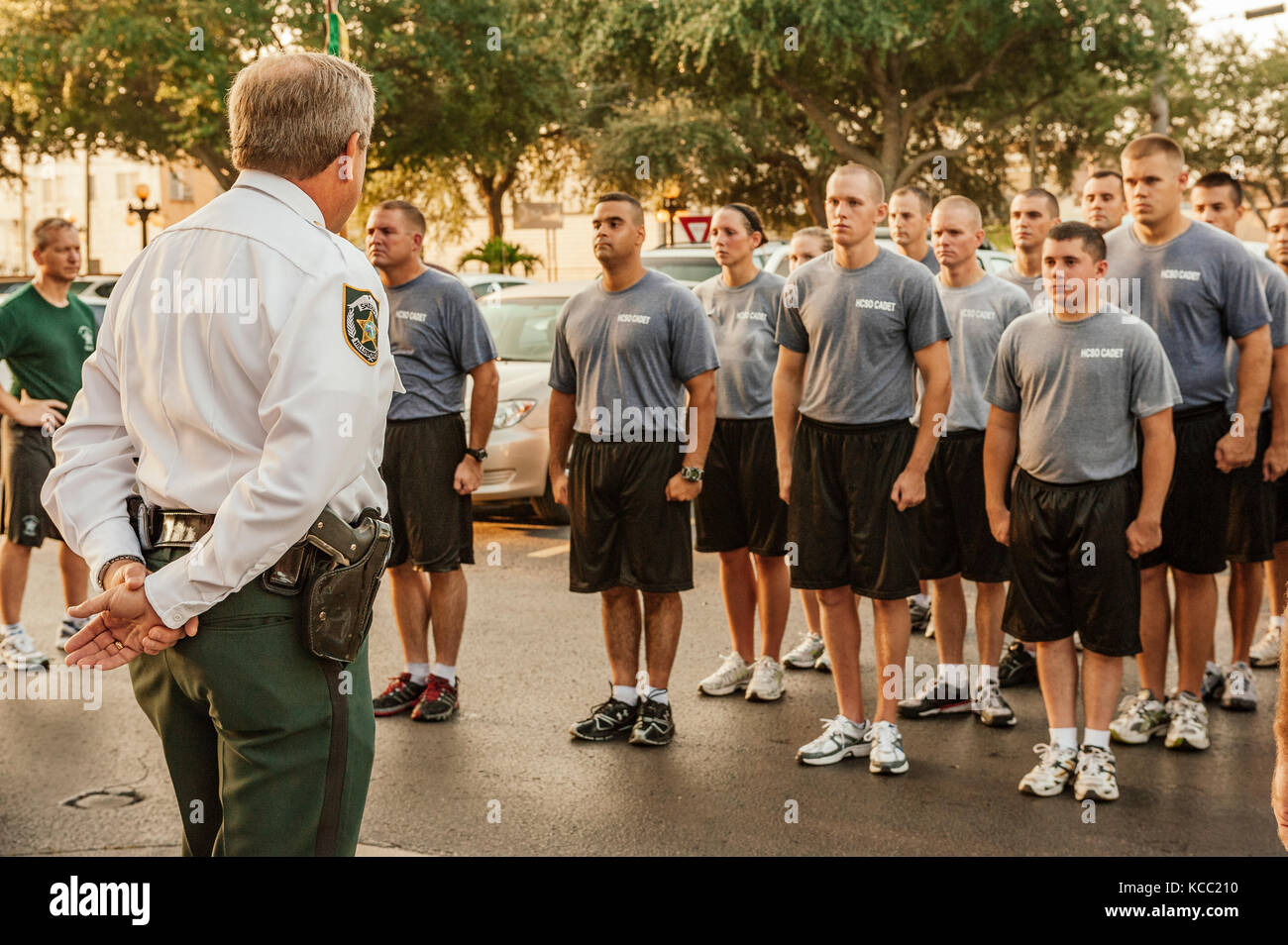 Polizia, applicazione della legge reclutare classe in piedi in formazione indirizzata dal comando officer dopo formazione gestita attraverso strade di Tampa, FL, Stati Uniti d'America. Foto Stock