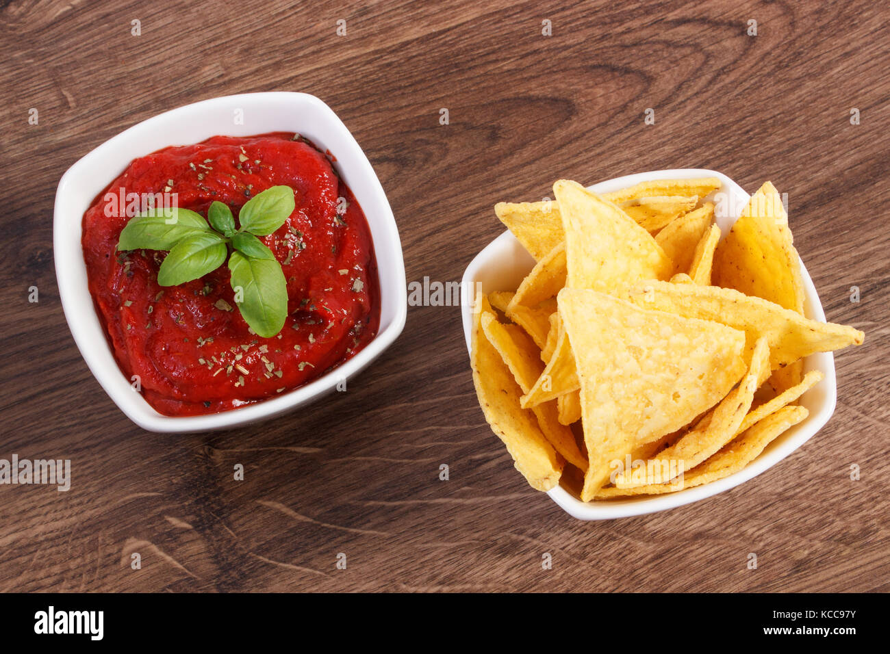Croccanti patatine e salsa con basilico in ciotole sulla scheda rustico, la nozione di restrizione mangiare malsano e cibi salati Foto Stock Croccanti patatine e salsa con basilico in ciotole sulla scheda rustico, la nozione di restrizione mangiare malsano e cibi salati Foto Stock
