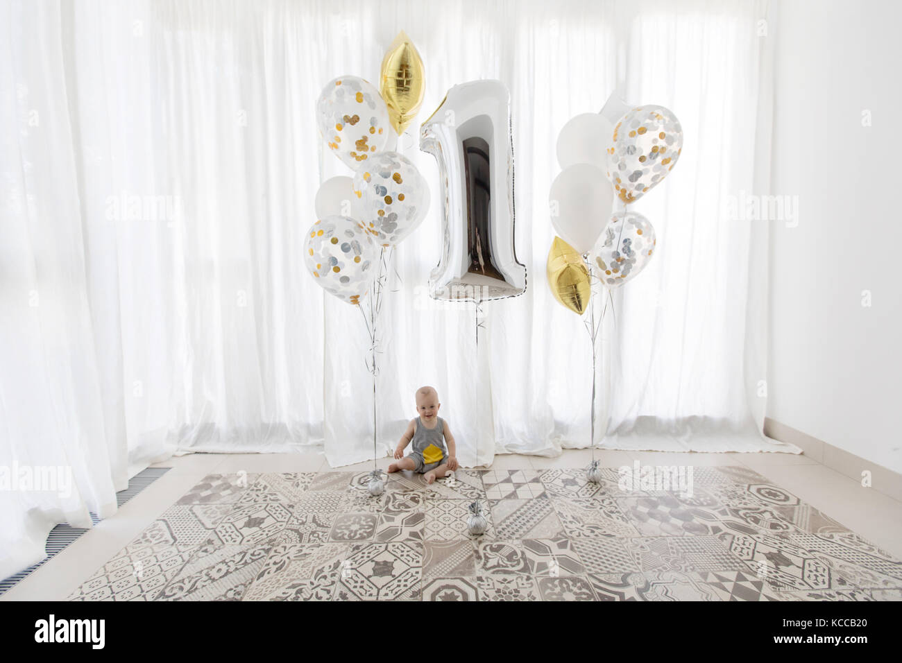 Carino baby con palloncini di festa su sfondo bianco Foto Stock