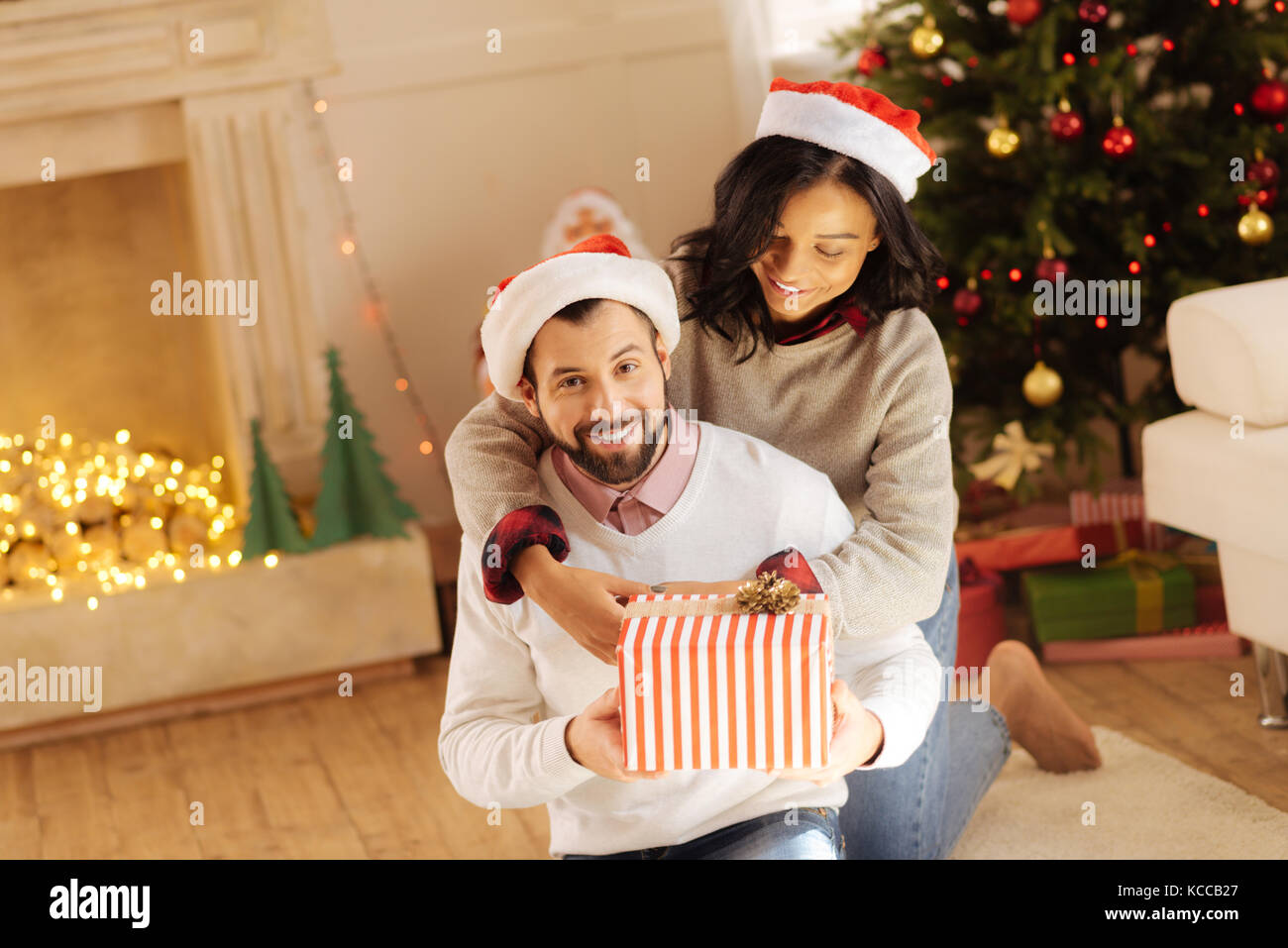 Donna amore abbracciando il marito alla vigilia di Natale Foto Stock