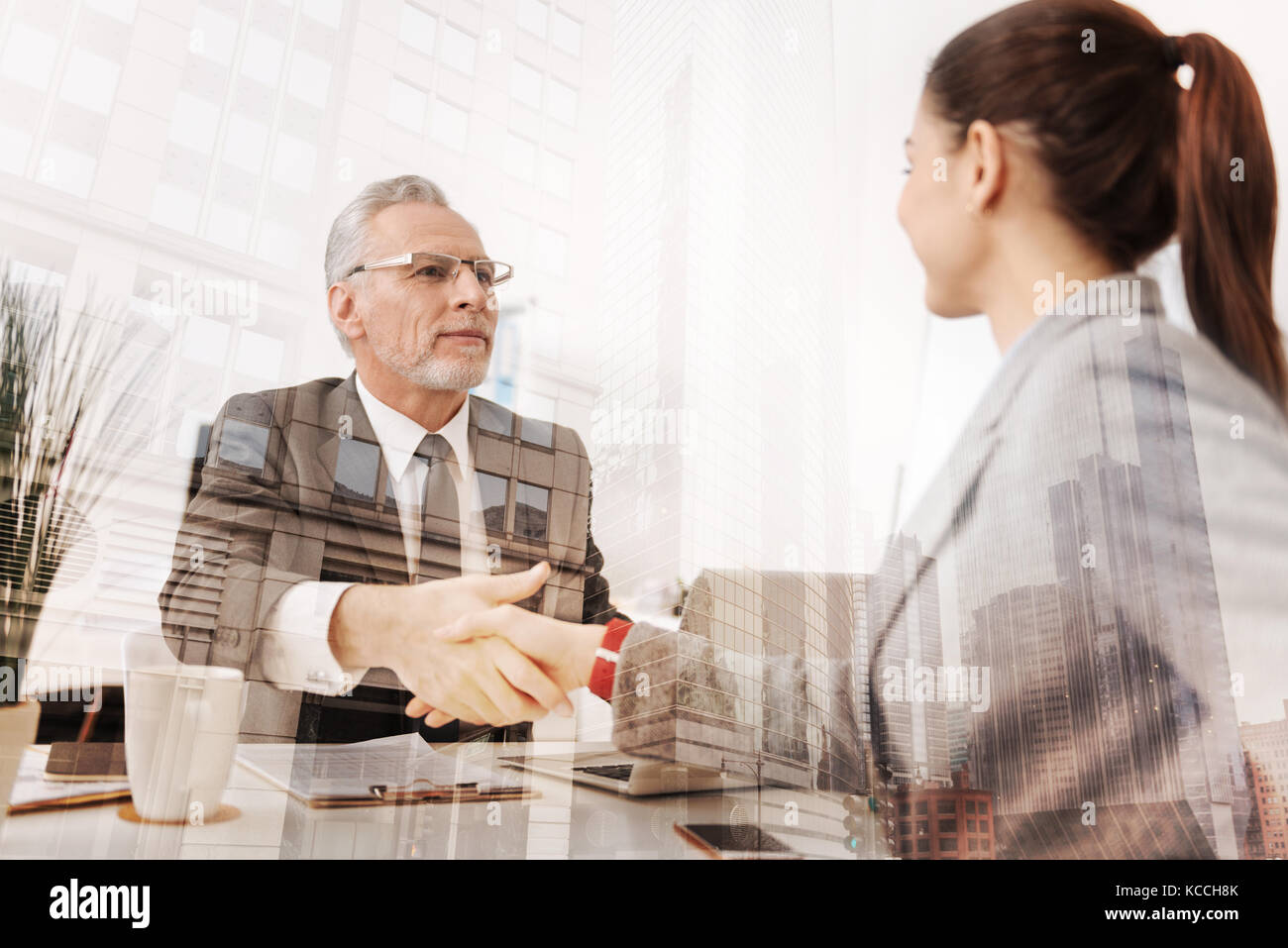 Allegro adulto boss agitando la mano di un nuovo dipendente di sesso femminile Foto Stock