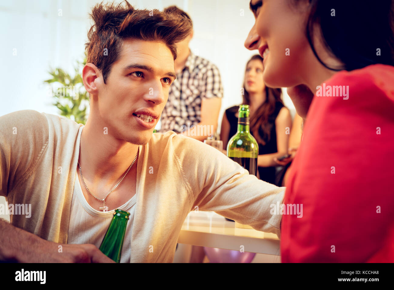 Carino giovane ragazzo sorridente sul partito di casa e sta guardando al suo fidanzato. messa a fuoco selettiva. Foto Stock