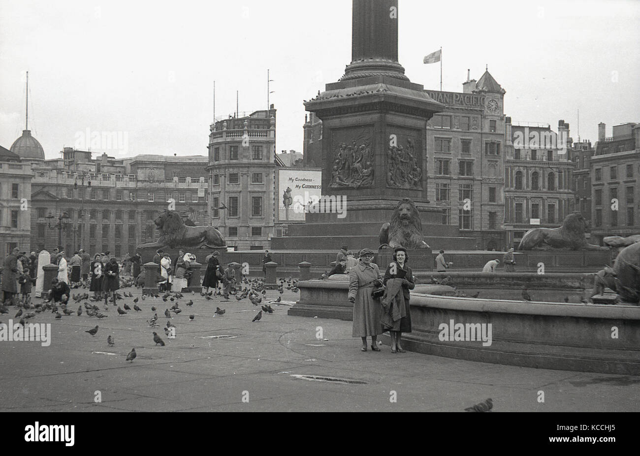 1944, immagine storica di alcuni visitatori della famosa Trafalgar Square nel centro di Londra, Inghilterra, Regno Unito. Persone che nutrono i piccioni alla base della colonna di Nelson. Foto Stock