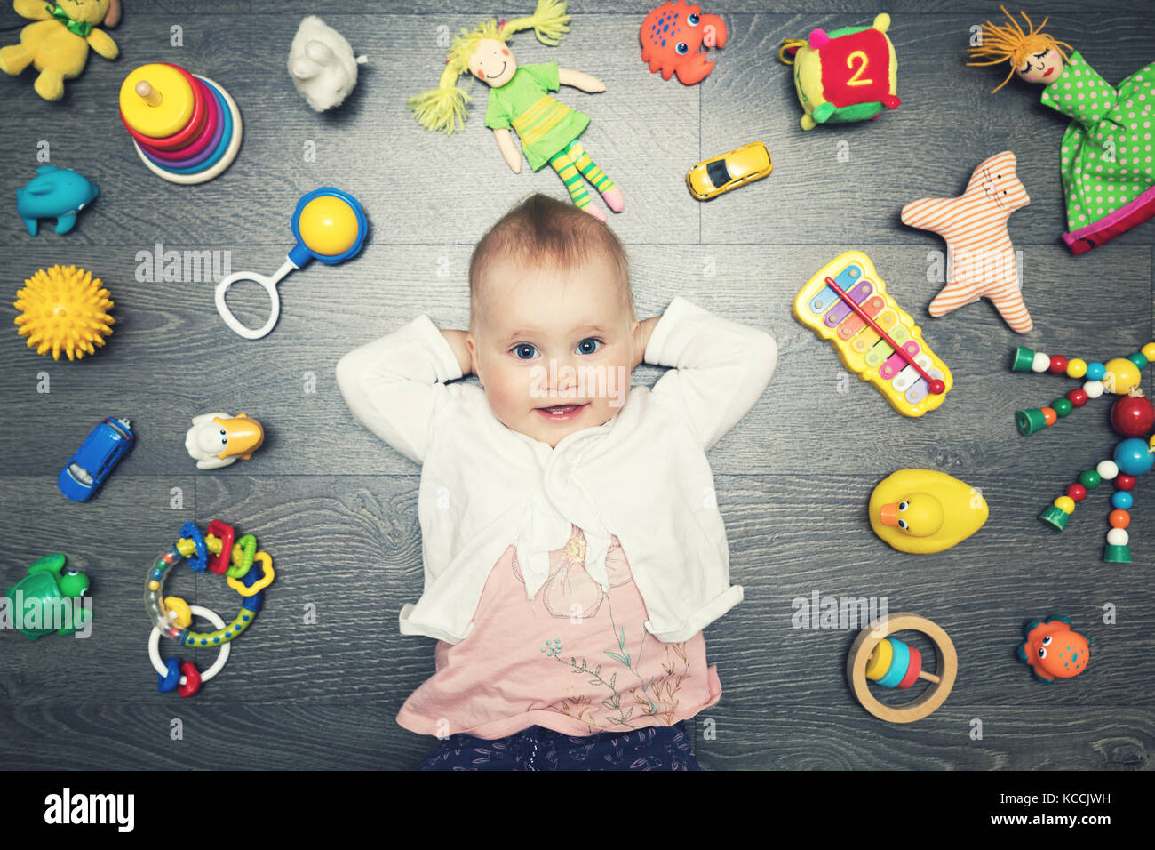 Carino bambina con un sacco di giocattoli sul pavimento. vista superiore Foto Stock