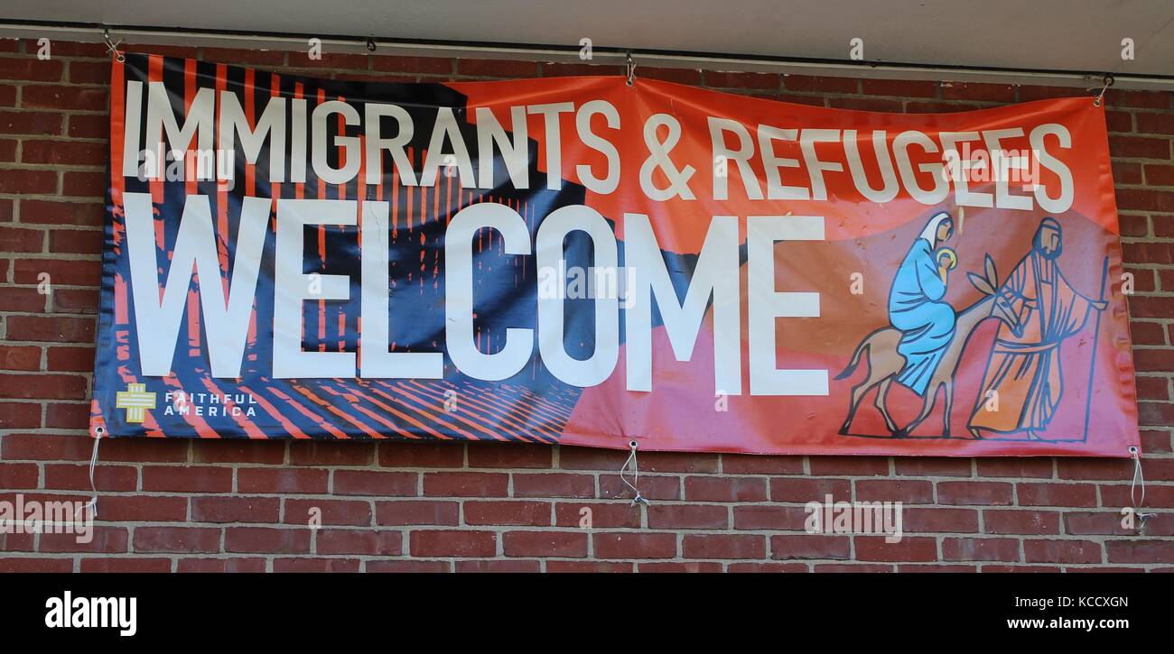 Un banner appesi in una comunità locale chiesa accogliere gli immigrati e i rifugiati Foto Stock