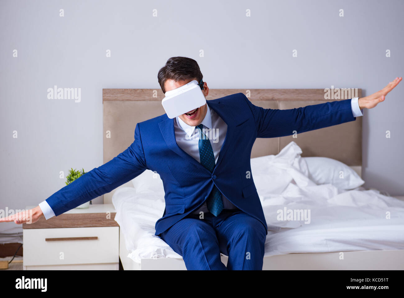 Imprenditore indossando una realtà virtuale auricolare in camera da letto Foto Stock