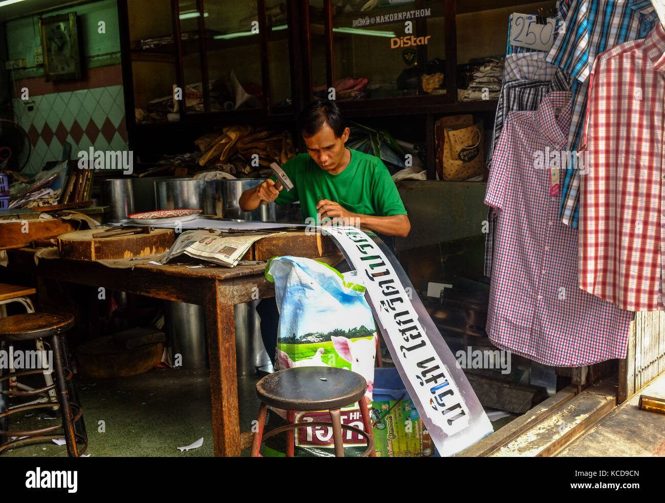 Uomo thailandese che produce insegne da un piccolo negozio a Bangkok, Thailandia Foto Stock