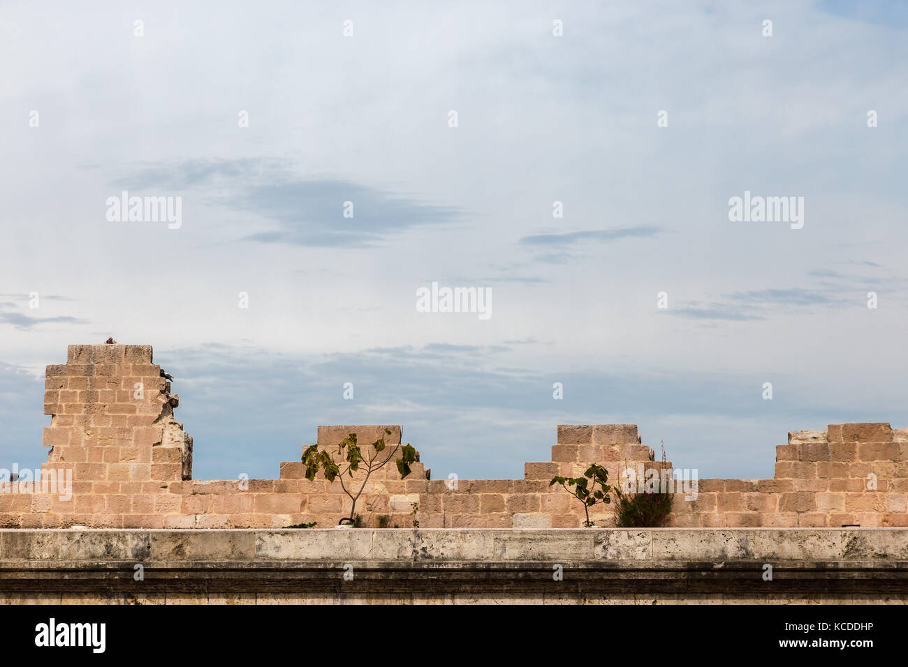 Dettaglio delle antiche mura con merli di spello città (Umbria, Italia), contro un cielo di nuvole Foto Stock