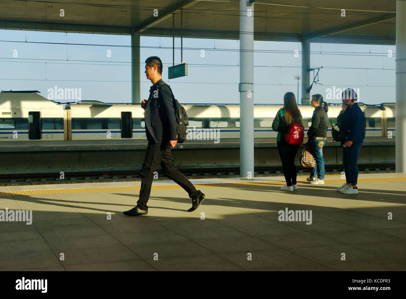 Piattaforma, binario e treno passeggeri su nuovi cinesi dalla stazione ferroviaria di baoding sul beijing shijiazhuang linea ad alta velocità. nella provincia di Hebei, Cina Foto Stock