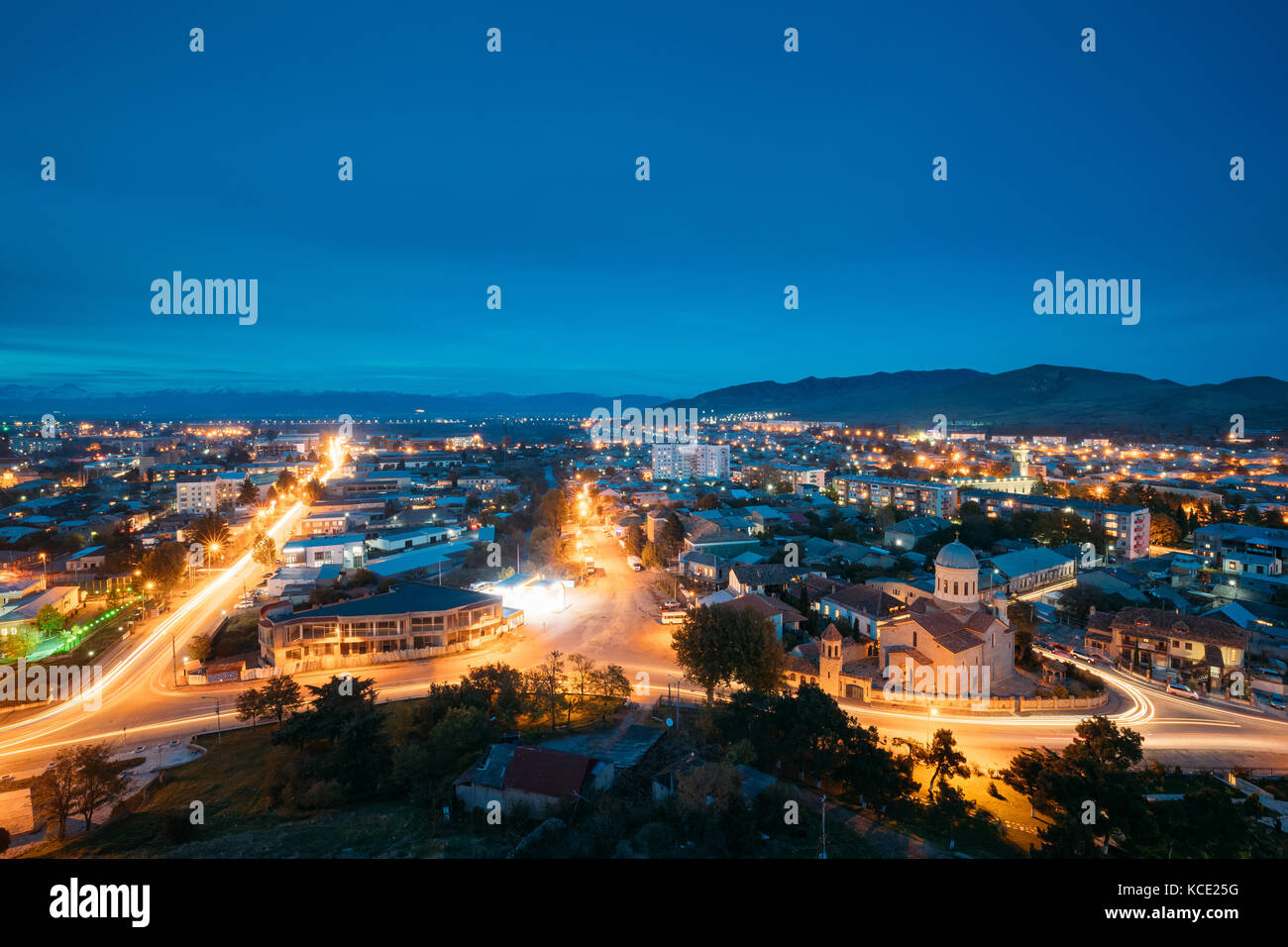 Gori, shida kartli regione, Georgia. gori cityscape di illuminazione serale sotto il cielo blu nel crepuscolo. cattedrale della Beata Vergine Maria nella notte ho Foto Stock