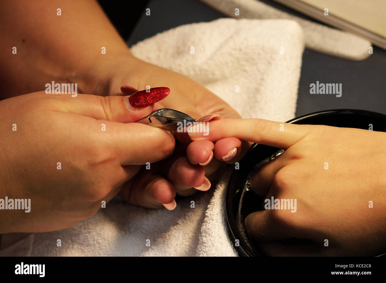 Manicurist a corsi di formazione mostra agli studenti come gestire le unghie con l aiuto del tronchese cuticole prima di applicare la gomma lacca Foto Stock