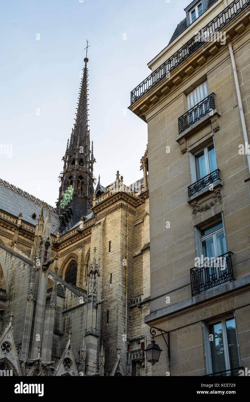Basso angolo vista del campanile della cattedrale di Notre Dame de Paris cathedral al tramonto con un edificio residenziale in primo piano. Foto Stock