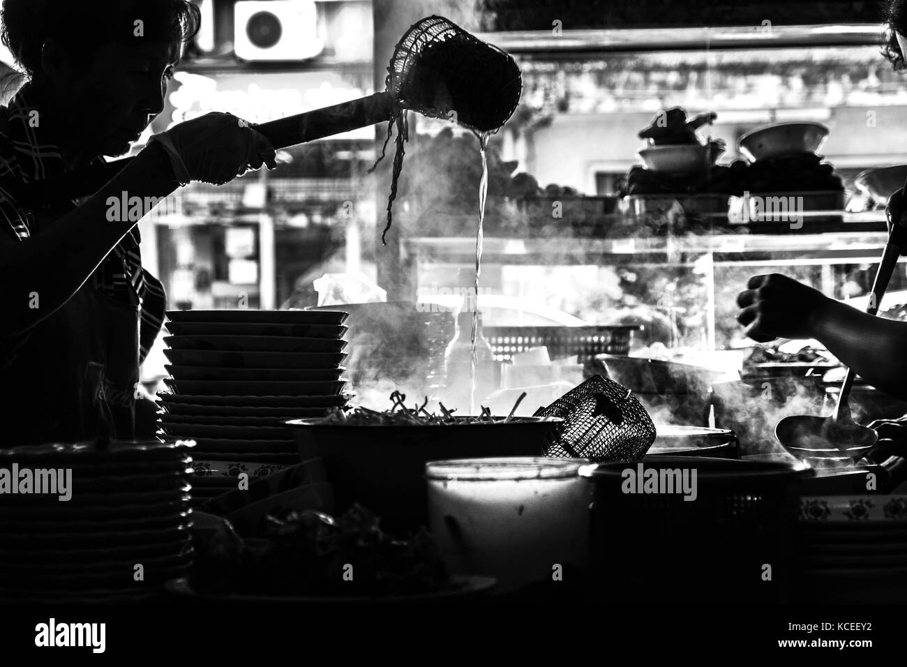 Donna asiatica la preparazione di un piatto di pasta in un locale a base di noodle shop in Phuket, Tailandia Foto Stock