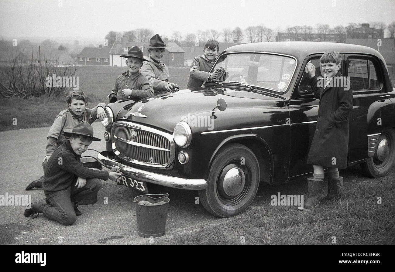 Anni '60, storico, Inghilterra, Regno Unito, ragazzo scouts pulizia di una macchina Hillman Minx durante Bob-a-lavoro settimana, una volta all'anno settimana quando il ragazzo locale scouts farebbe lavori dispari per una bob - il vecchio nome per una shiling. Foto Stock