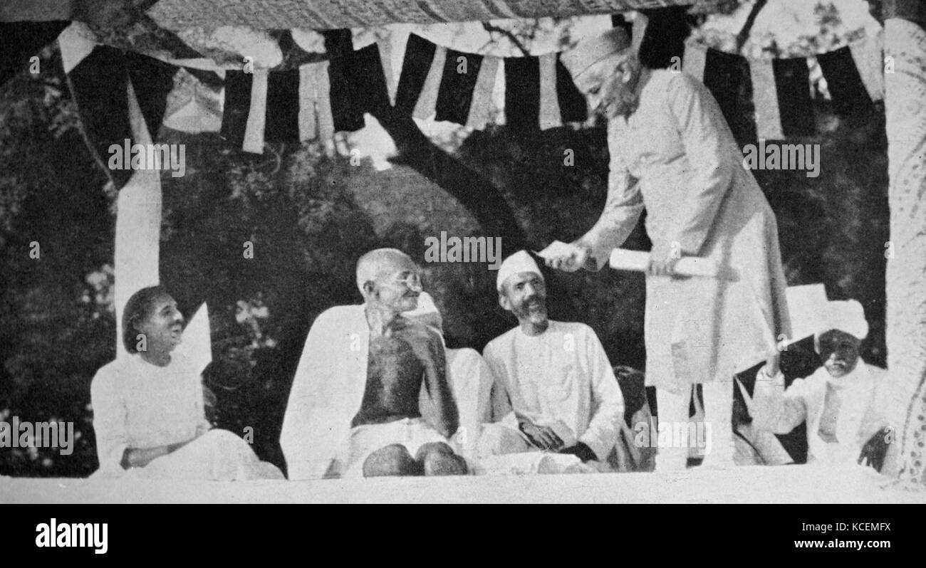 Il Mahatma Gandhi in occasione di una riunione di Allahabad, presieduta da Motilal Nehru (in piedi). Mohandas Gandhi (1869 - 1948) era il leader preminente dell'Indiano movimento di indipendenza in British-governata in India. Motilal Nehru (6 maggio 1861 - 6 febbraio 1931) era un avvocato indiano, un attivista del indiano del movimento nazionale e un importante leader del Congresso nazionale indiano, che ha anche servito come il Presidente del Congresso due volte, 1919-1920 e 1928-1929 Foto Stock