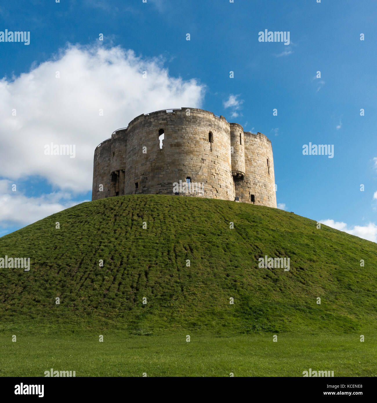 Soleggiata giornata autunnale con un luminoso cielo blu, oltre il ben noto punto di riferimento storico, la Torre di Clifford alta sul tumulo erboso - York, North Yorkshire, Inghilterra, Regno Unito. Foto Stock