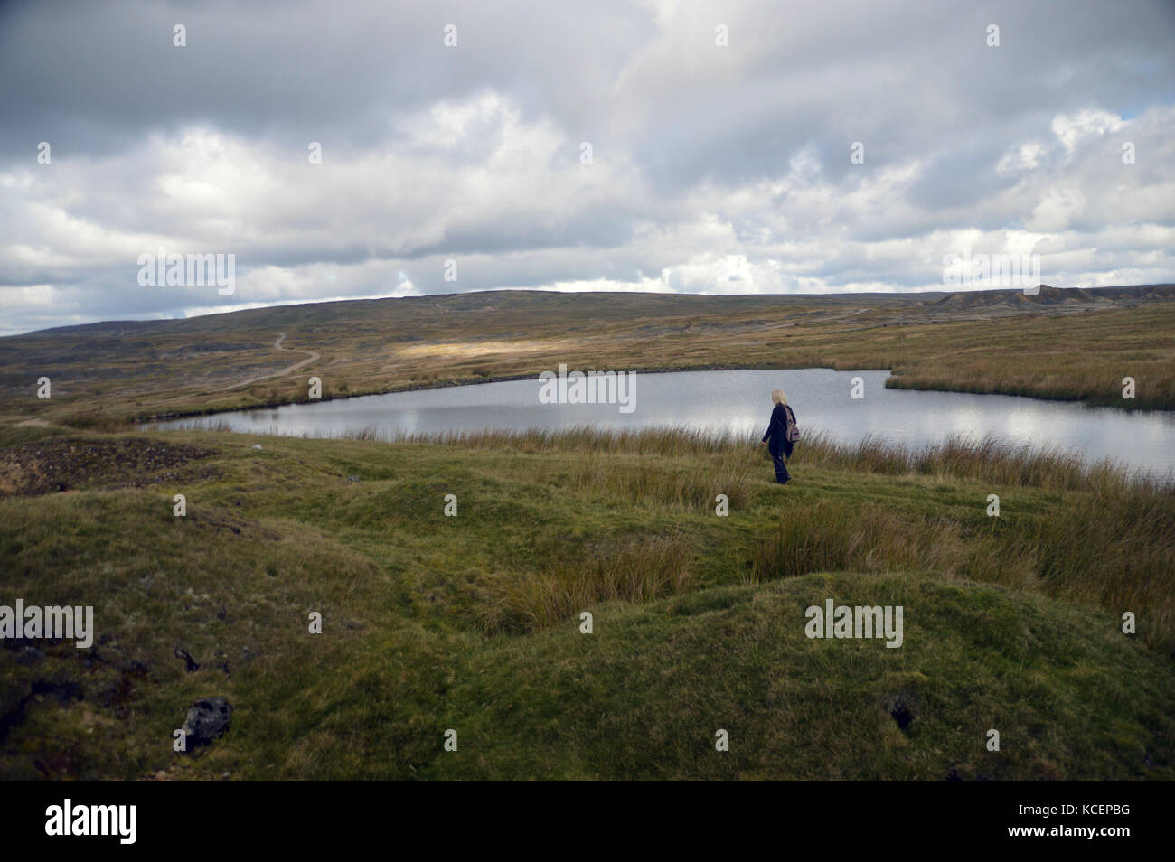 Lone donna escursionista a piedi passato coalgrovebeck serbatoio alta sul grassington moor, wharfedale, Yorkshire Dales National Park, Inghilterra, Regno Unito. Foto Stock