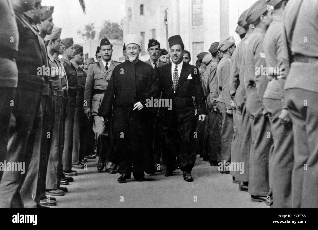 Haj Amin al-Husseini, il Gran Mufti di Gerusalemme e la testa di arabo Comitato superiore, la revisione di una guardia di honorat un villaggio della Galilea il 23 aprile 1947. Foto Stock