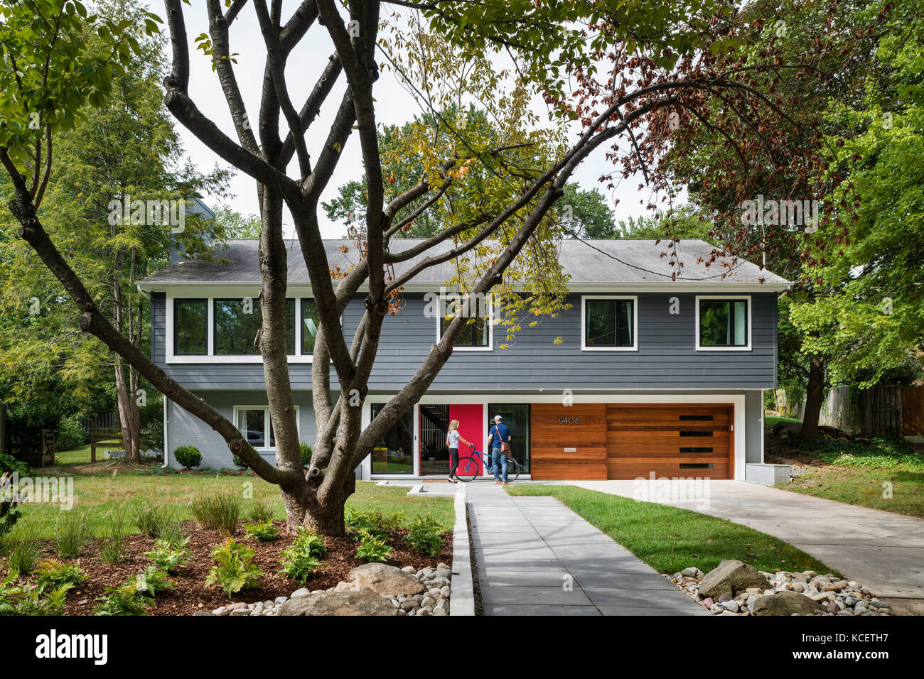 Esterno della casa dalla strada, mostrando i proprietari. Bruning Owen House, Chevy Chase, Stati Uniti. Architetto: Lou Balodemas architetti, 2015. Foto Stock