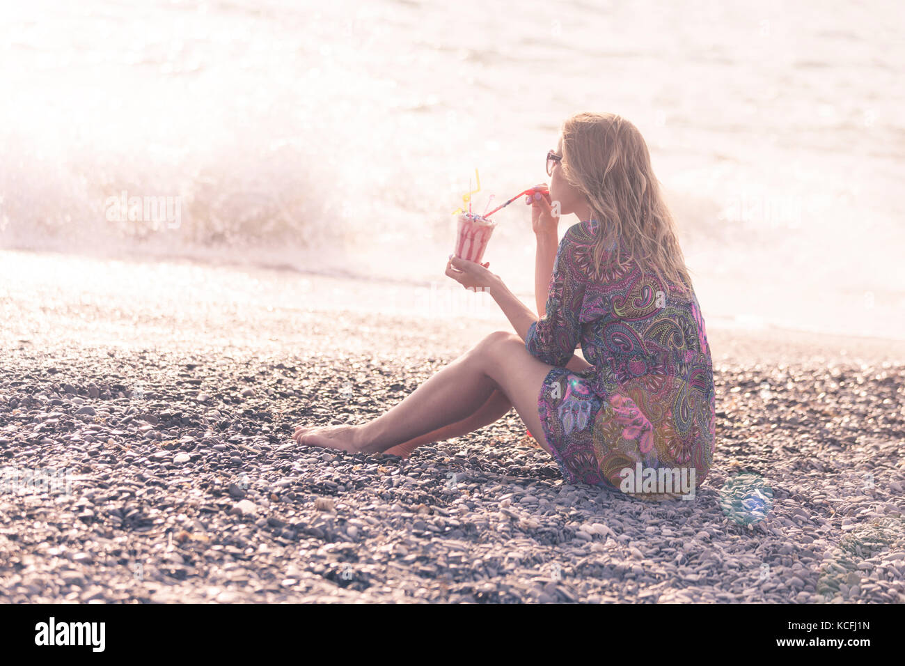 Bella donna sulla spiaggia con un bicchiere di latte Foto Stock