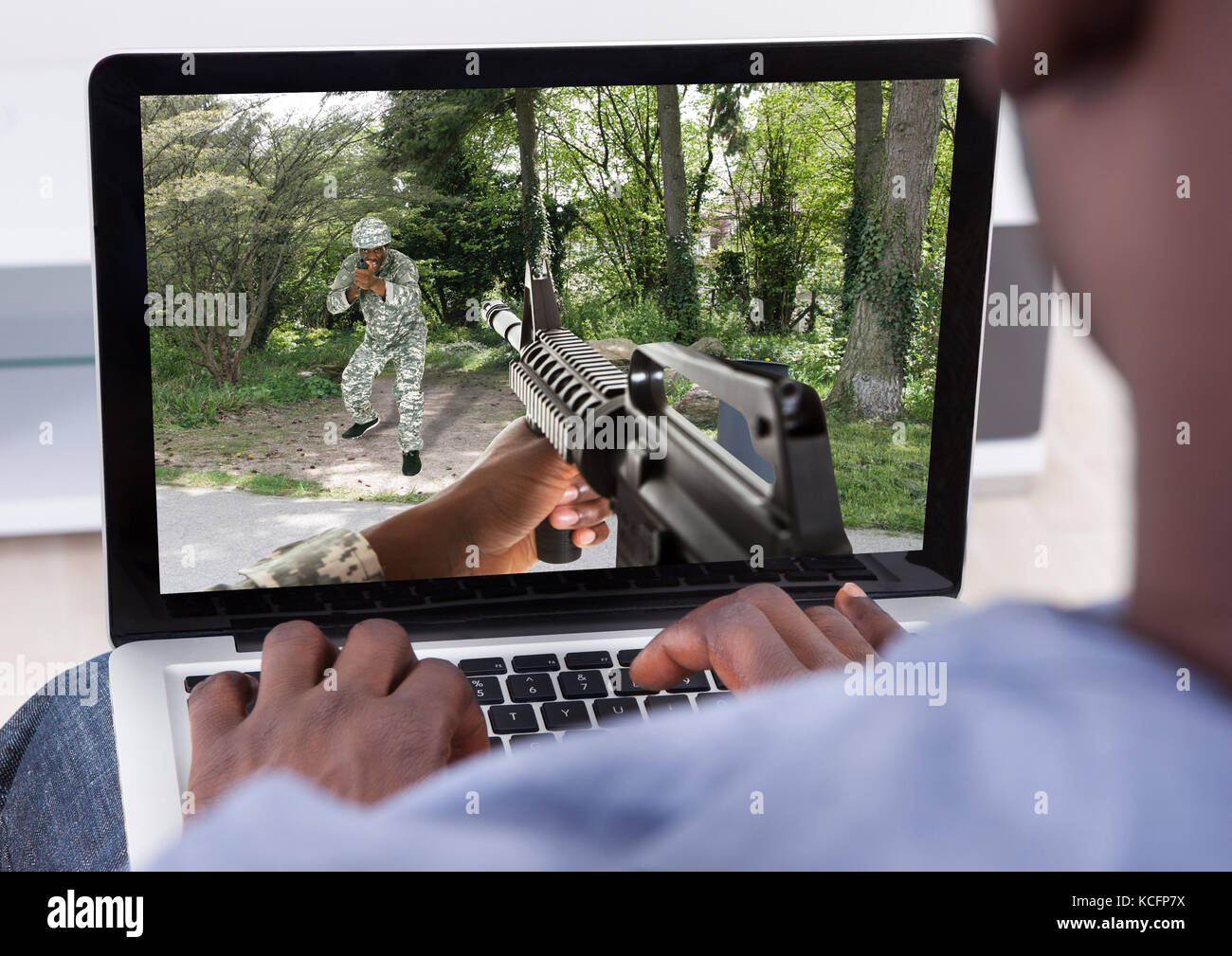 Close-up di uomo la riproduzione di un gioco di azione e sul suo computer portatile Foto Stock