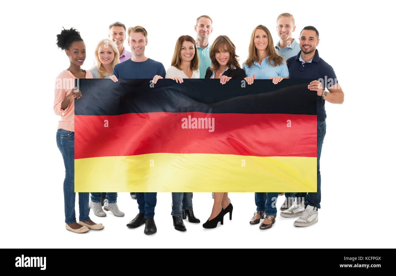 Le persone felici Holding bandiera tedesca contro uno sfondo bianco Foto Stock