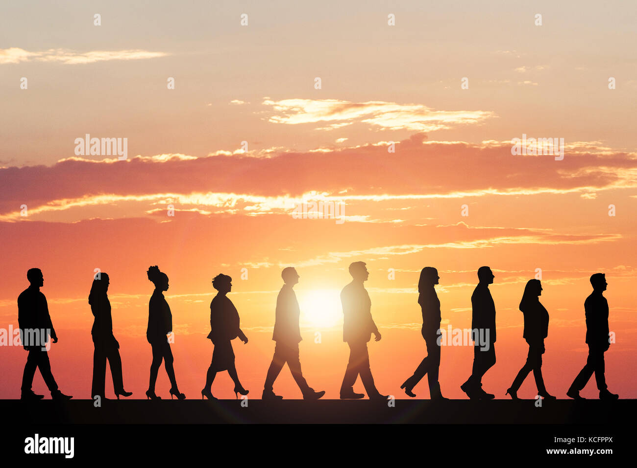 Silhouette di persone che camminano in linea contro il cielo drammatico  Foto stock - Alamy