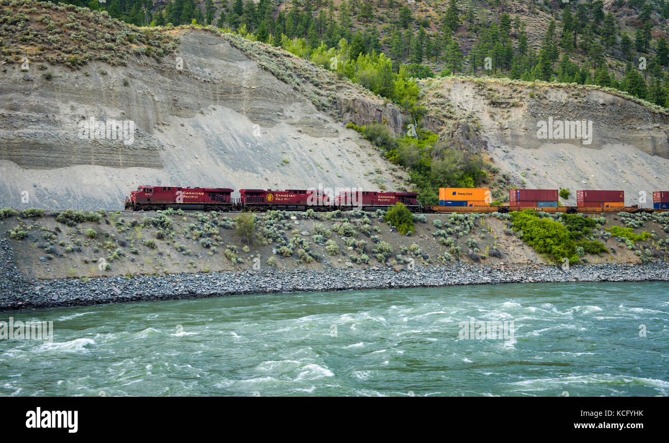 Treno merci della Canadian Pacific Railway che si muove lungo il fiume Thompson Foto Stock
