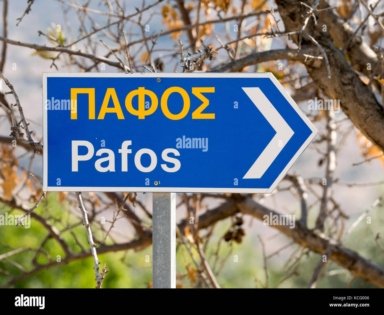 Cartello stradale nel villaggio di Episkopi scritto in inglese e greco che mostra la direzione di Pafos città nella Repubblica di Cipro. Foto Stock