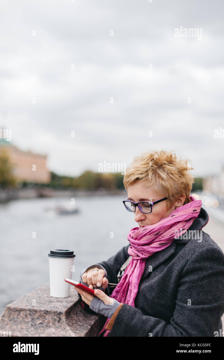 Donna con telefono sulla spianata Foto Stock