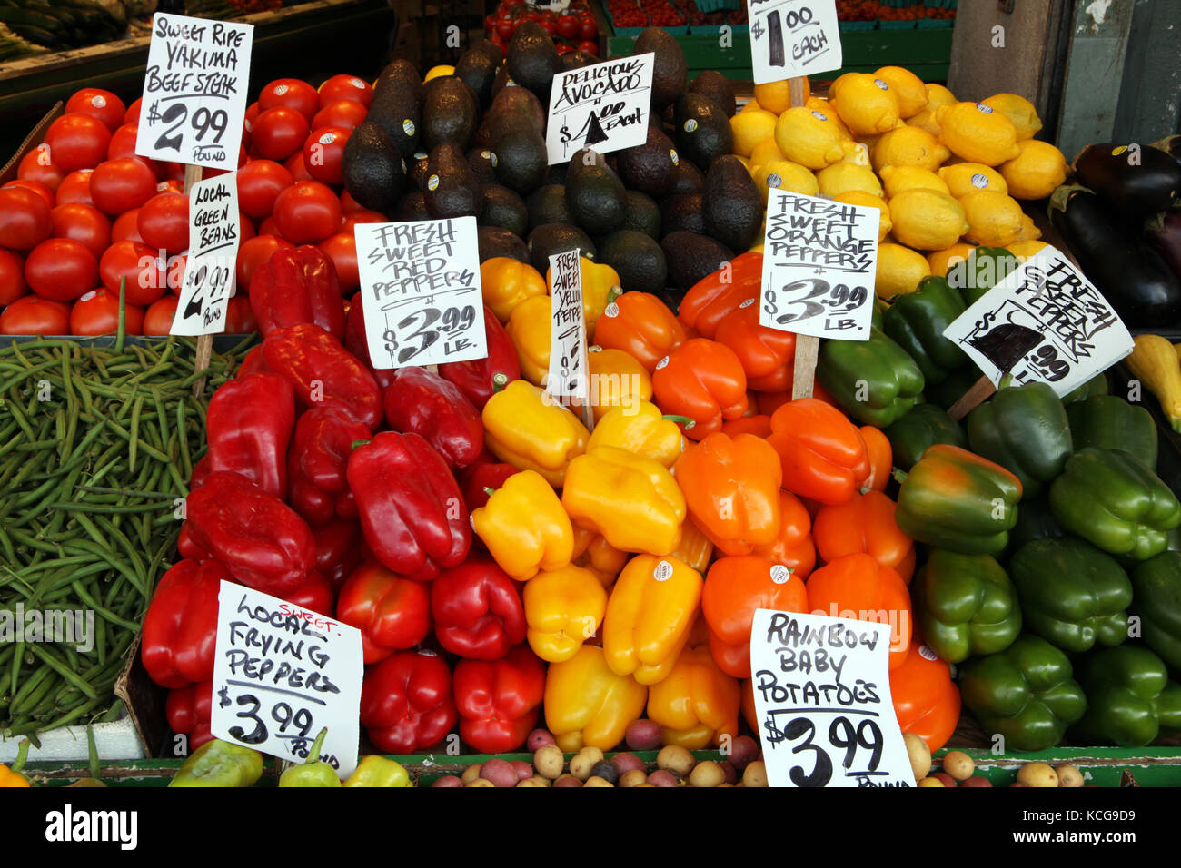 Pressione di stallo di mercato con il rosso e il giallo dei peperoni, pomodori e avocado, verde fagiolo, limoni & yakima, Seattle, Stati Uniti d'America Foto Stock
