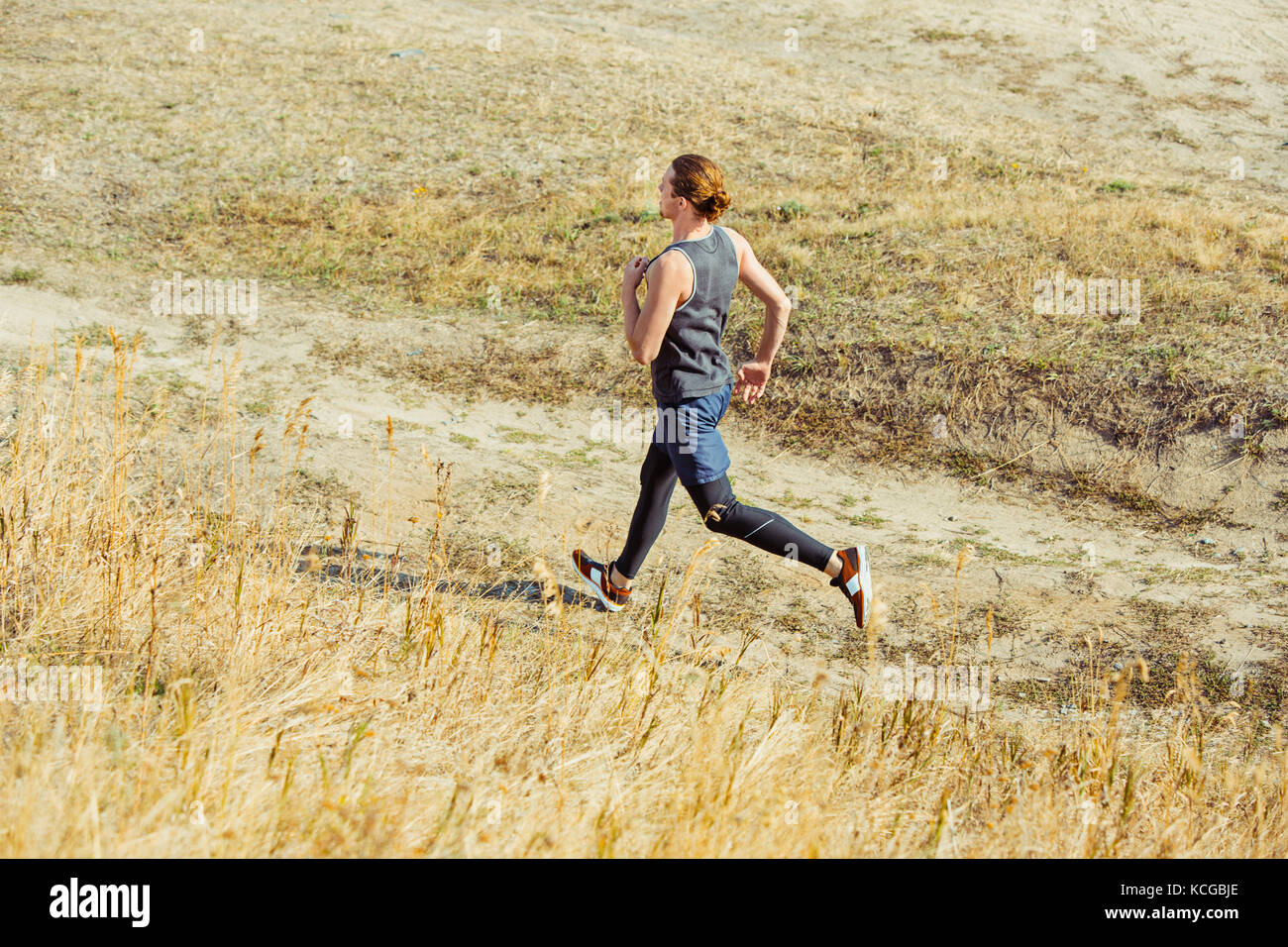 Esecuzione di sport. l uomo runner in volata outdoor in scenic natura. Montare muscolare atleta maschio formazione trail running per correre la maratona. Foto Stock