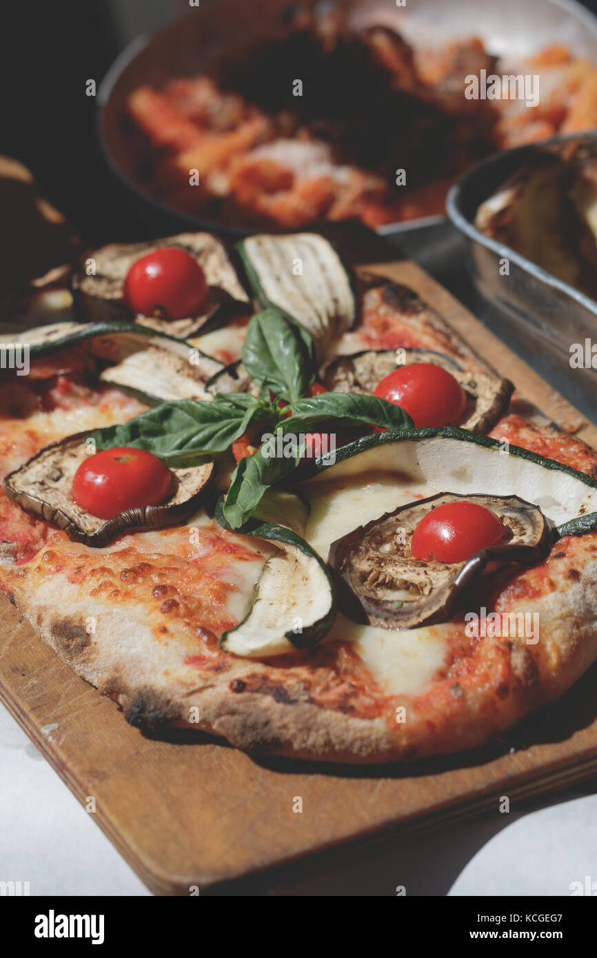 Cucina di strada in Italia: pizza con pomodori e basilico e melanzane Foto Stock