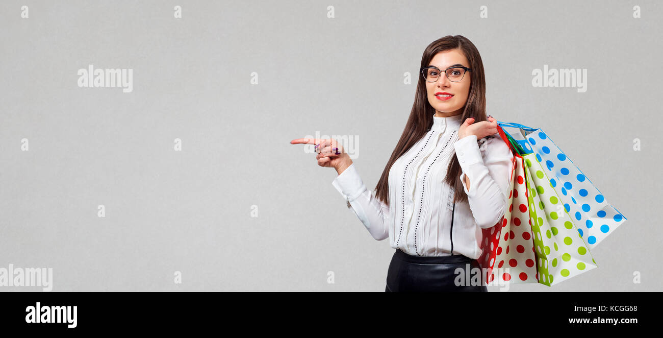 Bruna giovane donna con confezioni regalo che mostra Thumbs up backgr Foto Stock