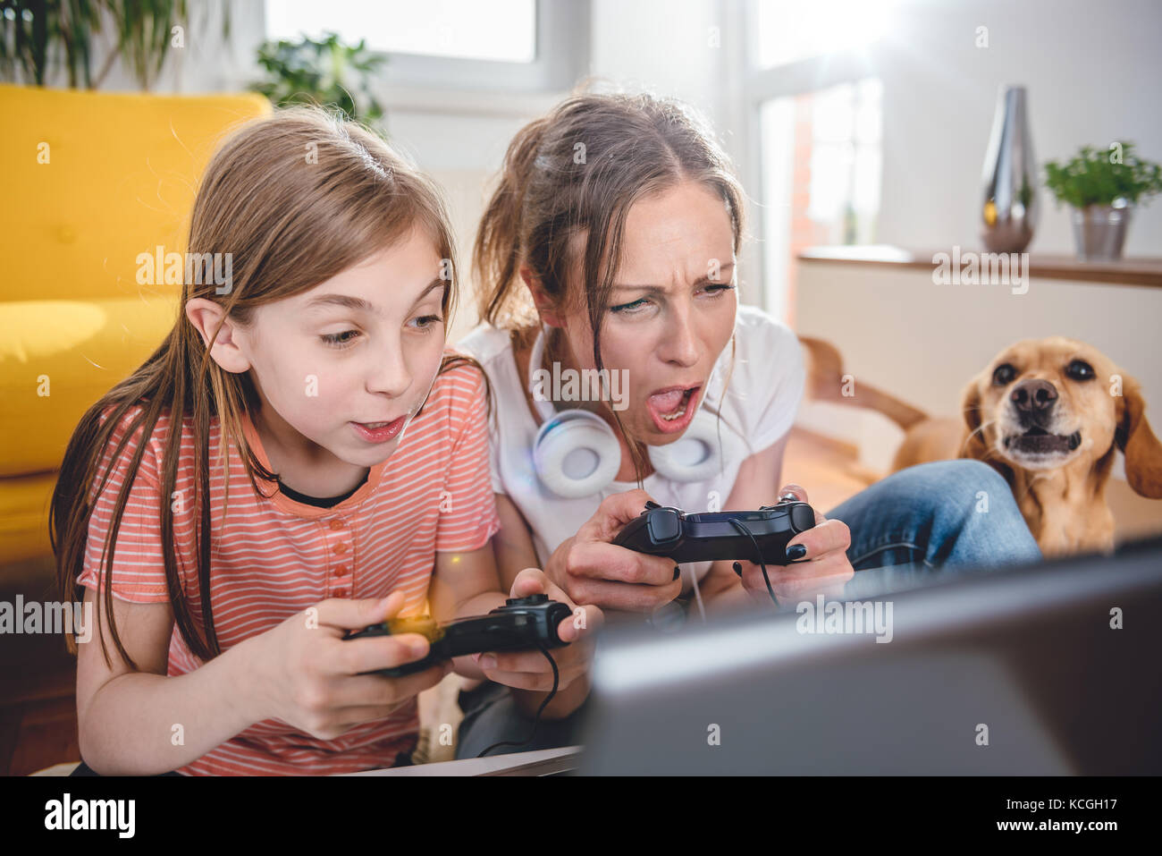 Madre e figlia di giocare con i videogiochi su laptop a casa Foto Stock