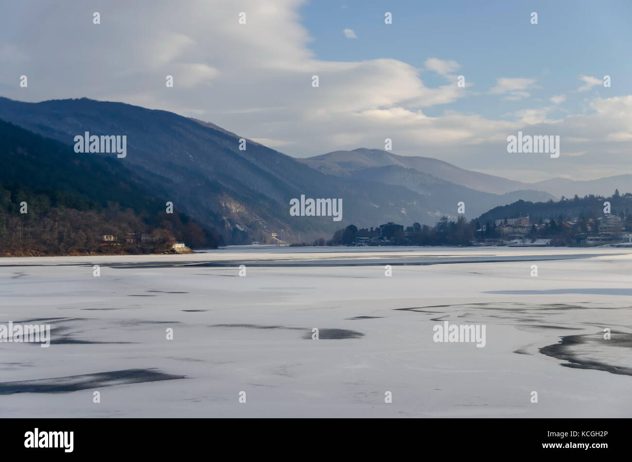 In scena con lago ghiacciato, montagna innevata, glade, foresta e residenziale quartiere di borgo bulgaro pancharevo, sofia, Bulgaria Foto Stock