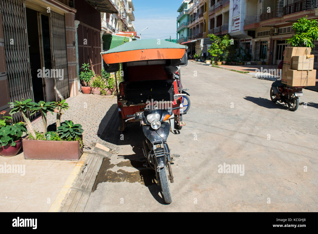 Tuk-tuk, auto rickshaw, parcheggiata in una zona residenziale, l'attesa dei passeggeri in una strada in Phnom Penh Cambogia. Trasporto tipici del sud est asiatico Foto Stock