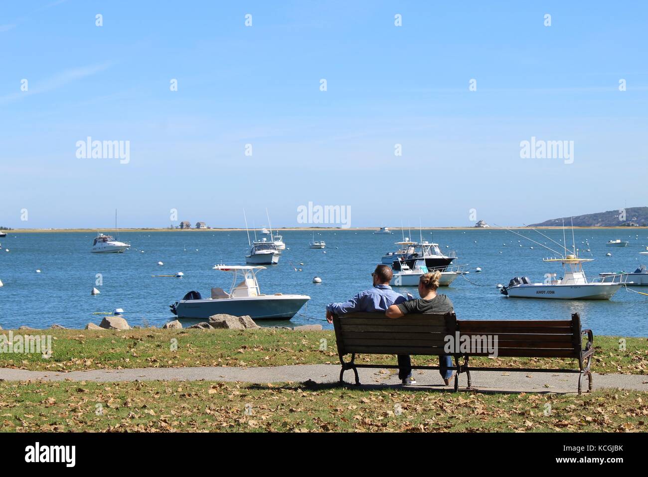 La gente seduta su una panchina in un parco vicino all'oceano atlantico in Nuova Inghilterra Foto Stock