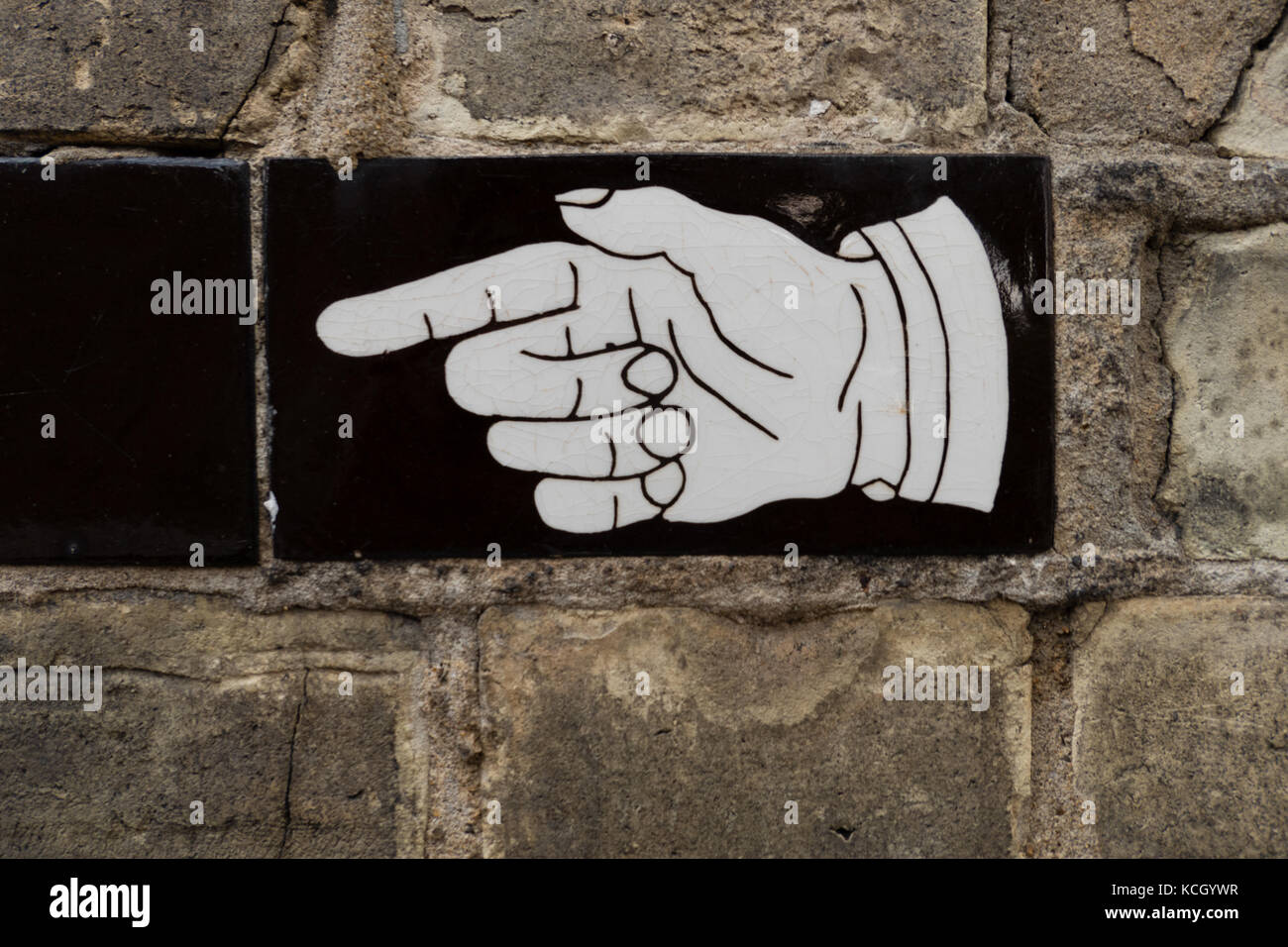 Una mano di puntamento segno su una piastrella vintage in Hampstead, Londra Foto Stock