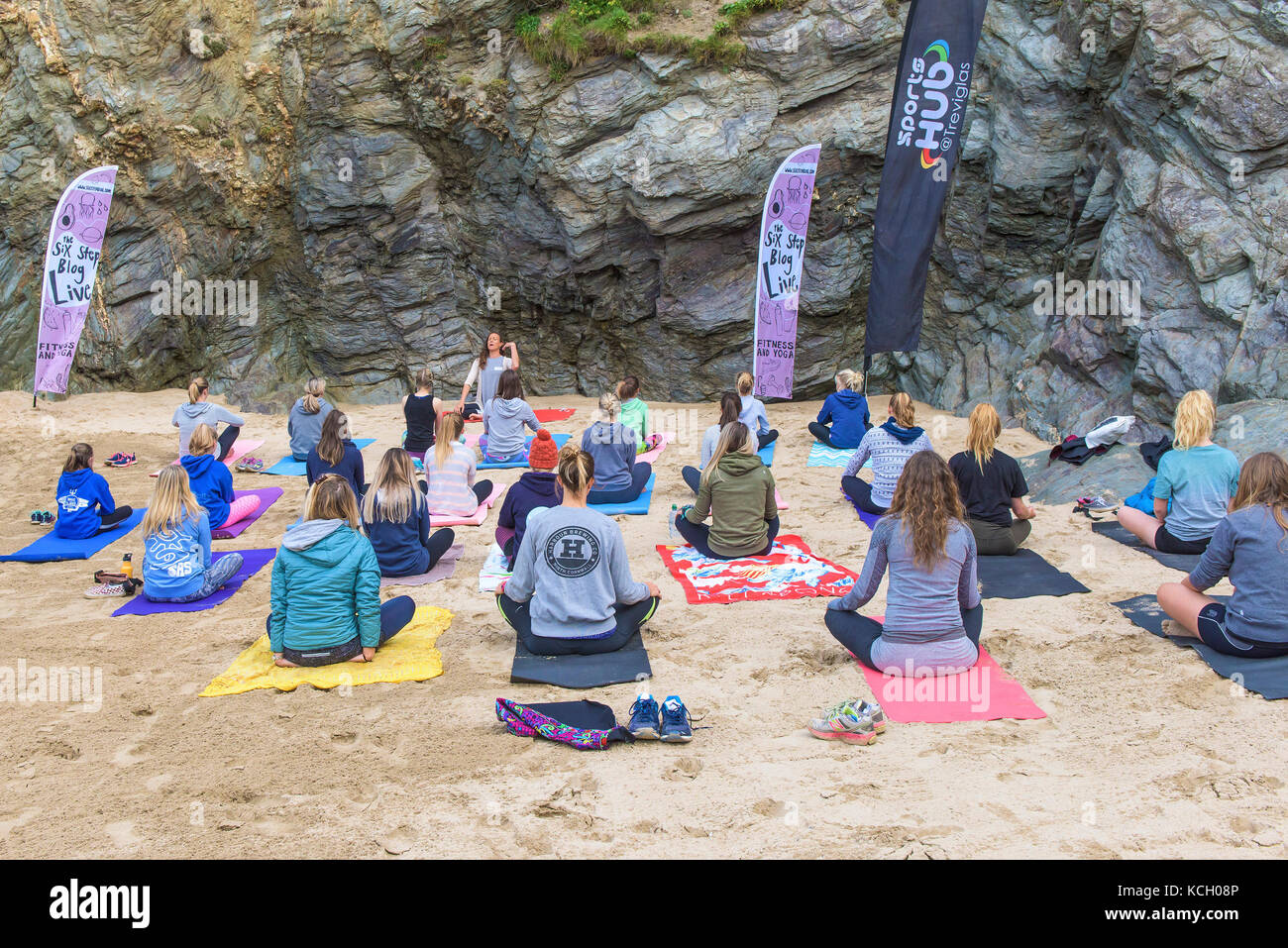 Un gruppo di donne a praticare yoga su una spiaggia - Surf Betty's Festival un festival che si tiene a Newquay emancipazione delle donne attraverso il fitness e surf. Foto Stock