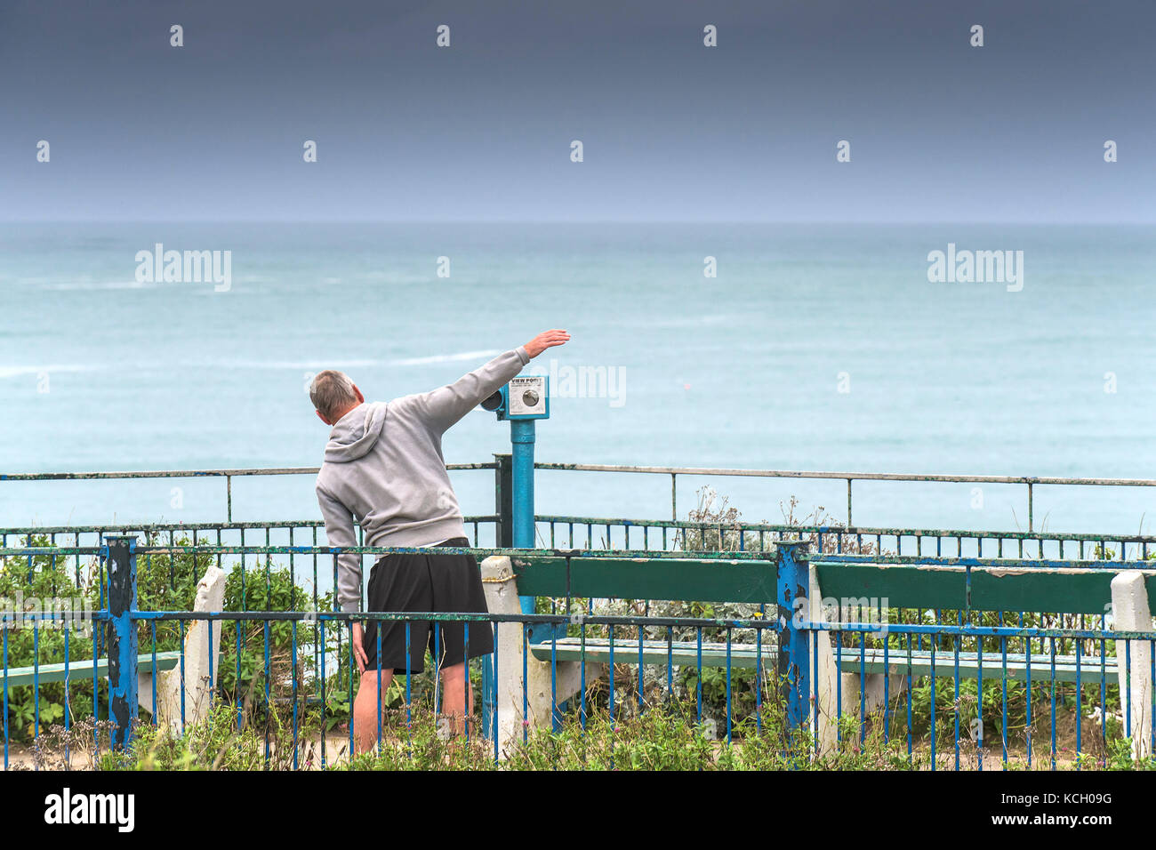 Allenamento di mattina presto - un uomo che si esercita in un'area salotto con vista sul mare in Cornovaglia. Foto Stock