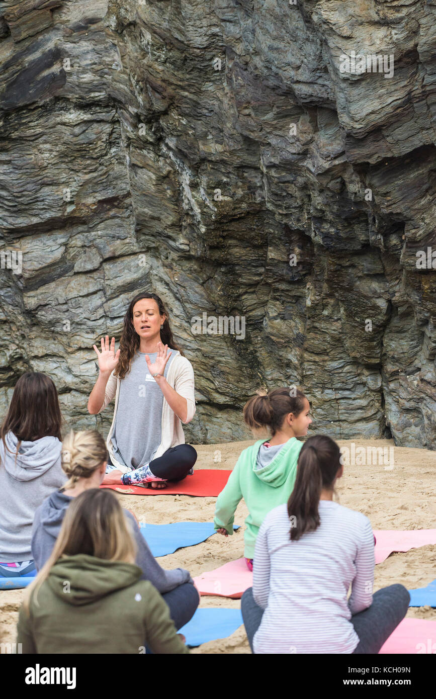Un womens' gruppo a praticare yoga su una spiaggia - Surf Betty's Festival - un festival che si tiene a Newquay emancipazione delle donne attraverso il fitness e surf. Foto Stock